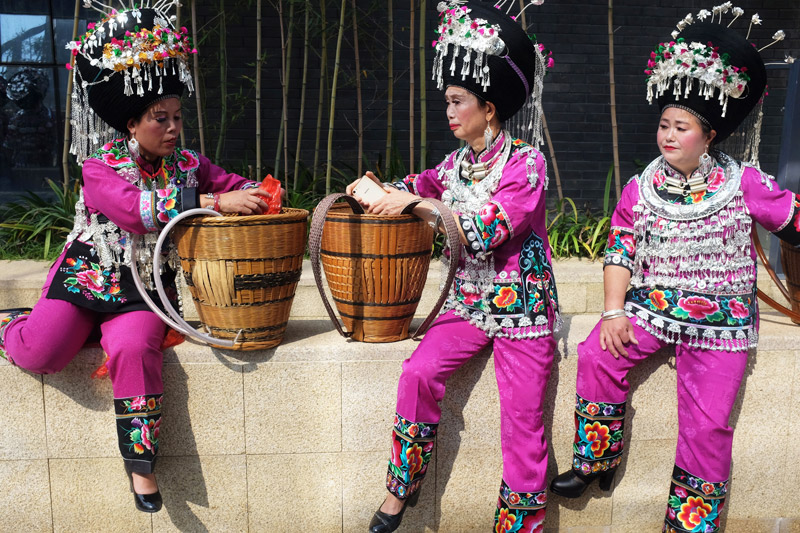 hk_c_湖南省鳳凰縣，幾位穿着傳統苗族服裝的婦女演出結束後在路邊休息。.jpg