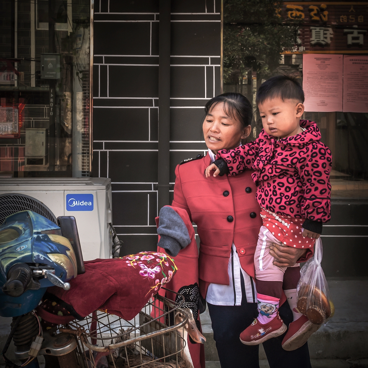 hk_c_抱着孩子來賣鴨子的母親，有空還饒有興緻地刷刷手機視頻.jpg